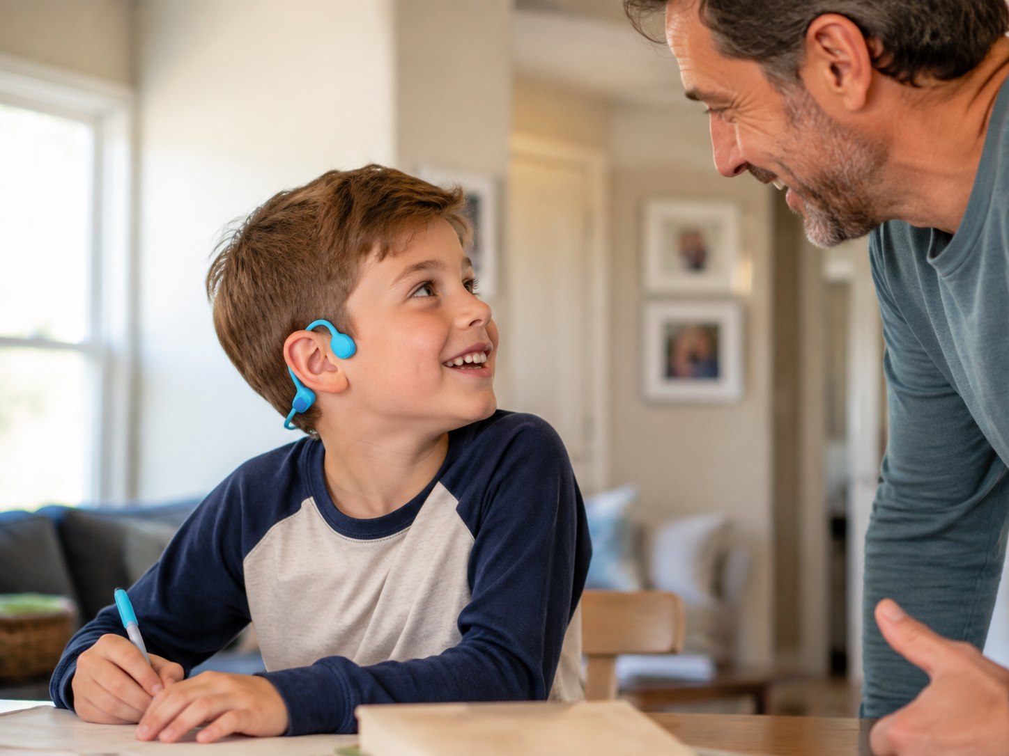 Child responding to a parent while wearing open-ear headphones at home